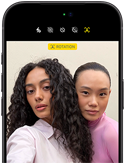 iPhone 18 Pro, noir, face avant, affichant deux modèles qui posent pour la caméra, mettant en avant la caméra avant Center Stage